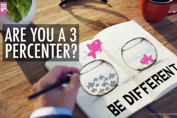 Notebook with fishbowl drawings; one contains many fish, the other has one. Pink fish jump between bowls. Text reads "Are you a 3 percenter? Be different." Coffee cup and plant in the background.
